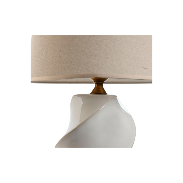 Lámpara de sobremesa con base de porcelana blanca en forma de espiral y pantalla de algodón en tono beige.