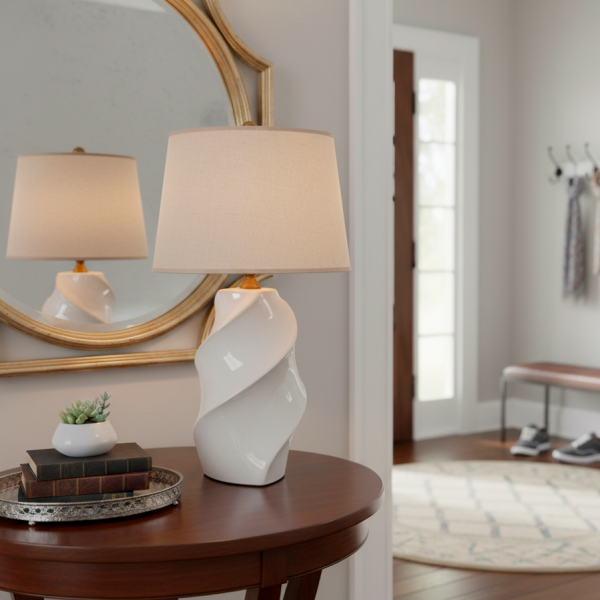 Lámpara de sobremesa con base de porcelana blanca en forma de espiral y pantalla de algodón en tono beige.